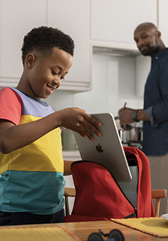 Student packing his MacBook laptop into his backpack