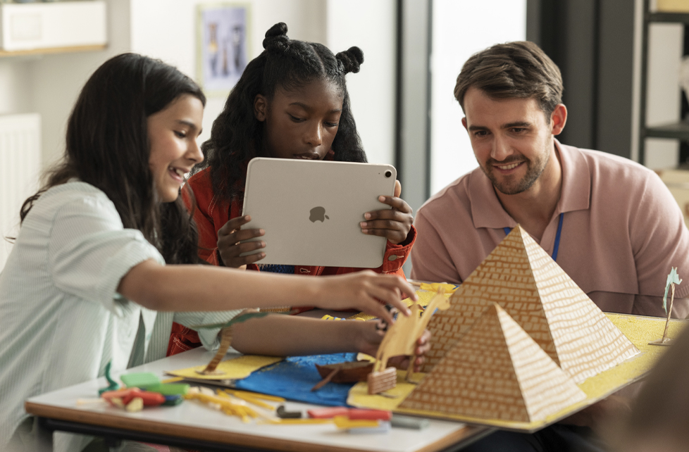 Teacher and two students using an iPad as a camera in the classroom